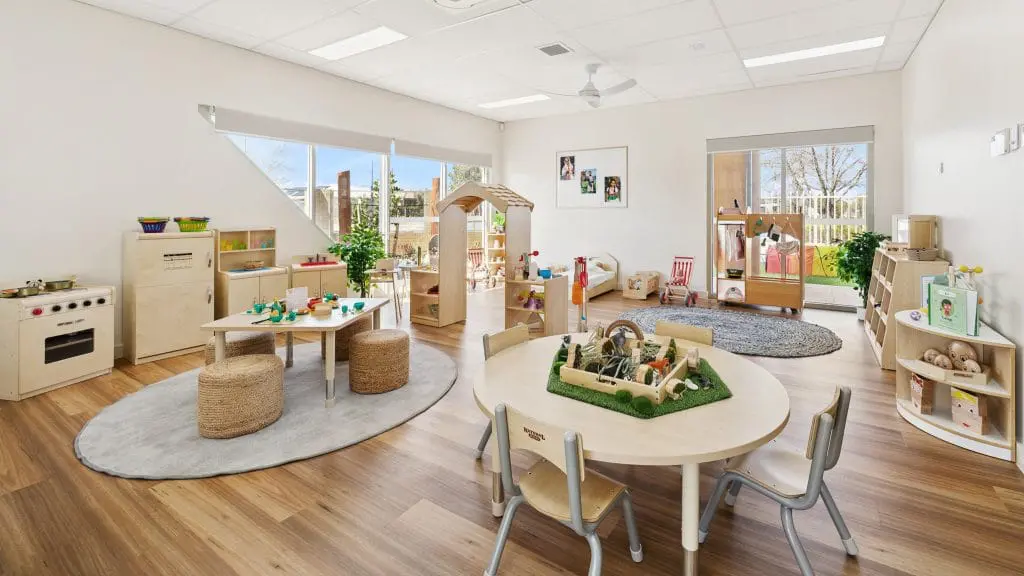 Interior view of Buttercups Perth Childcare showcasing a thoughtfully designed learning environment. The room features natural wooden furniture, interactive play areas, and large windows that provide plenty of natural light.