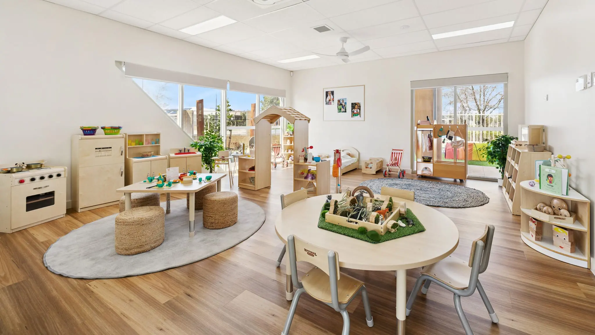 Interior view of Buttercups Perth Childcare showcasing a thoughtfully designed learning environment. The room features natural wooden furniture, interactive play areas, and large windows that provide plenty of natural light.