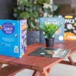 A collection of children's space-themed books, including "My Very First Space Book," displayed on a small wooden table at Buttercups Perth Childcare. A small green potted plant adds a touch of greenery to the setup, creating a welcoming learning environment.