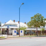 Exterior view of Buttercups Perth Childcare, showcasing a charming heritage-style building with modern outdoor play areas, secure fencing, and vibrant signage, providing a welcoming and safe environment for children to learn and grow.