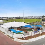 Aerial view of Buttercups Perth Childcare showcasing its modern building design, secure outdoor play areas with shade sails, and surrounding neighbourhood amenities.