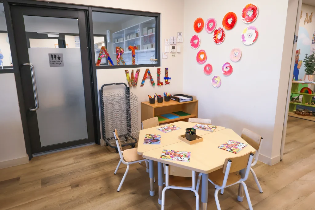 The arts and crafts corner at Buttercups Perth Childcare showcases children's artwork proudly displayed on the wall. A well-prepared table invites creativity with a hands-on craft project ready for little artists.