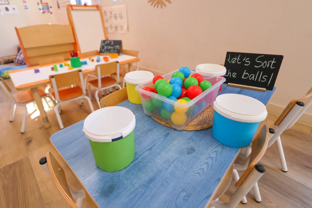 The interactive ball sorting activity at Buttercups Perth Childcare helps children learn colours through play. Children match each ball to the corresponding bucket, developing cognitive and fine motor skills.