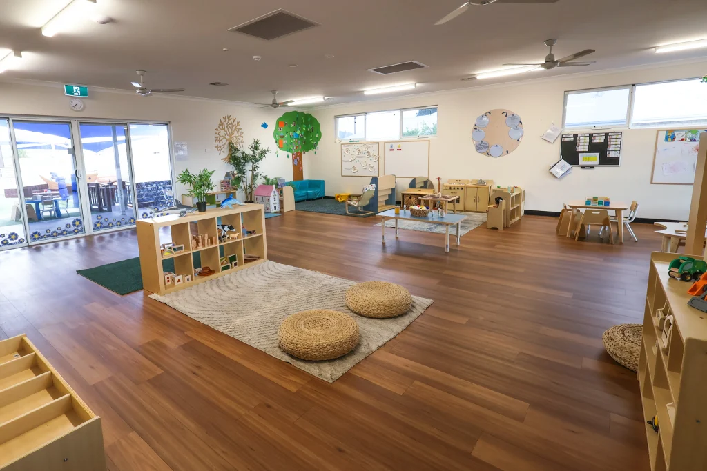 Interior view of Buttercups Perth Childcare showcasing a spacious and thoughtfully designed learning environment. The room features natural wooden furniture, interactive play areas, and large windows that provide plenty of natural light.