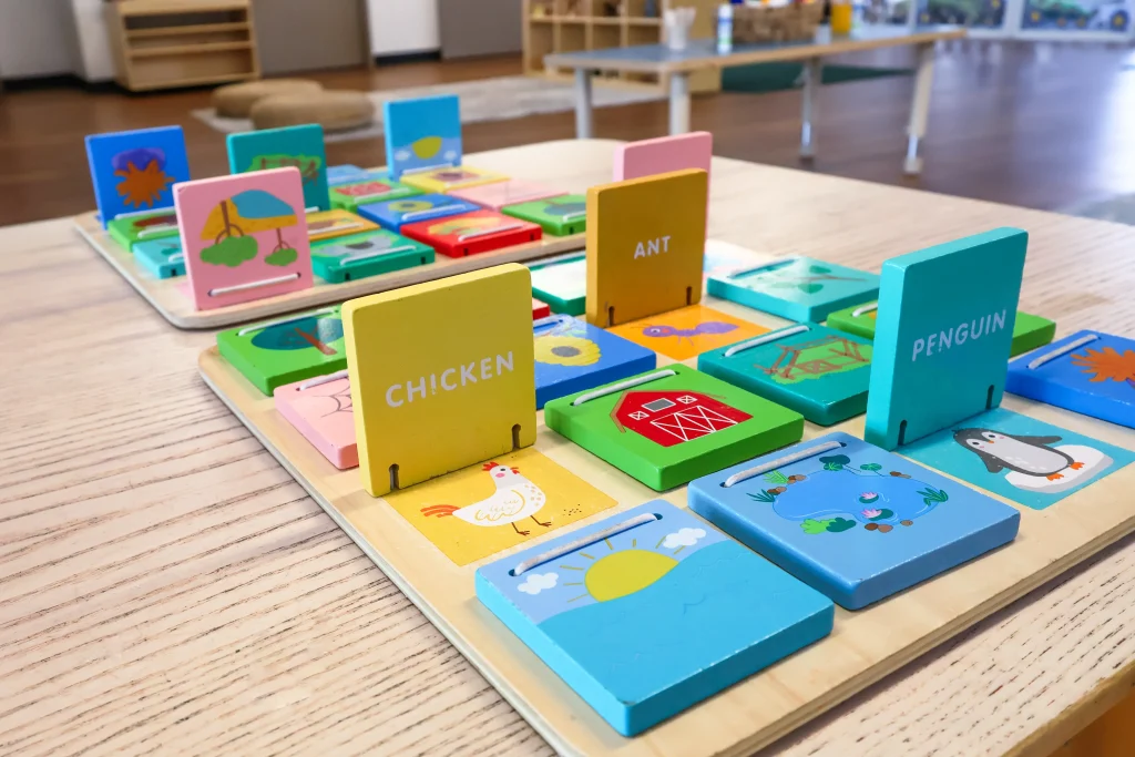 Close-up view of an engaging educational activity at Buttercups Perth Childcare. This colourful wooden matching game encourages children to pair words with corresponding images, supporting early literacy and cognitive development.