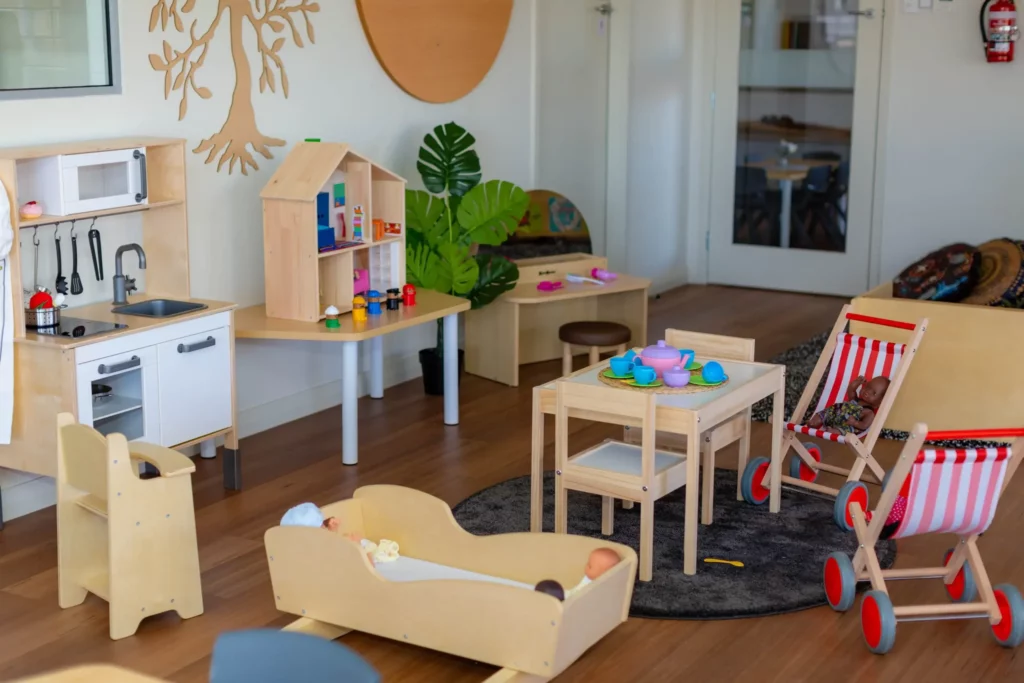 Indoor play area at a Perth childcare centre, featuring a pretend kitchen, dollhouse, and play furniture to inspire imaginative and creative play.