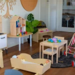 Indoor play area at a Perth childcare centre, featuring a pretend kitchen, dollhouse, and play furniture to inspire imaginative and creative play.