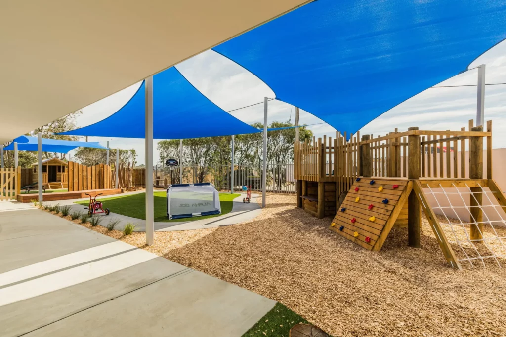 Outdoor play area at a Perth childcare centre, featuring climbing equipment, shaded spaces, and a safe, engaging environment for children.