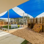 Outdoor play area at a Perth childcare centre, featuring climbing equipment, shaded spaces, and a safe, engaging environment for children.