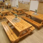 Wooden tables adorned with plants, creating a welcoming eating area at Buttercups Perth Childcare.