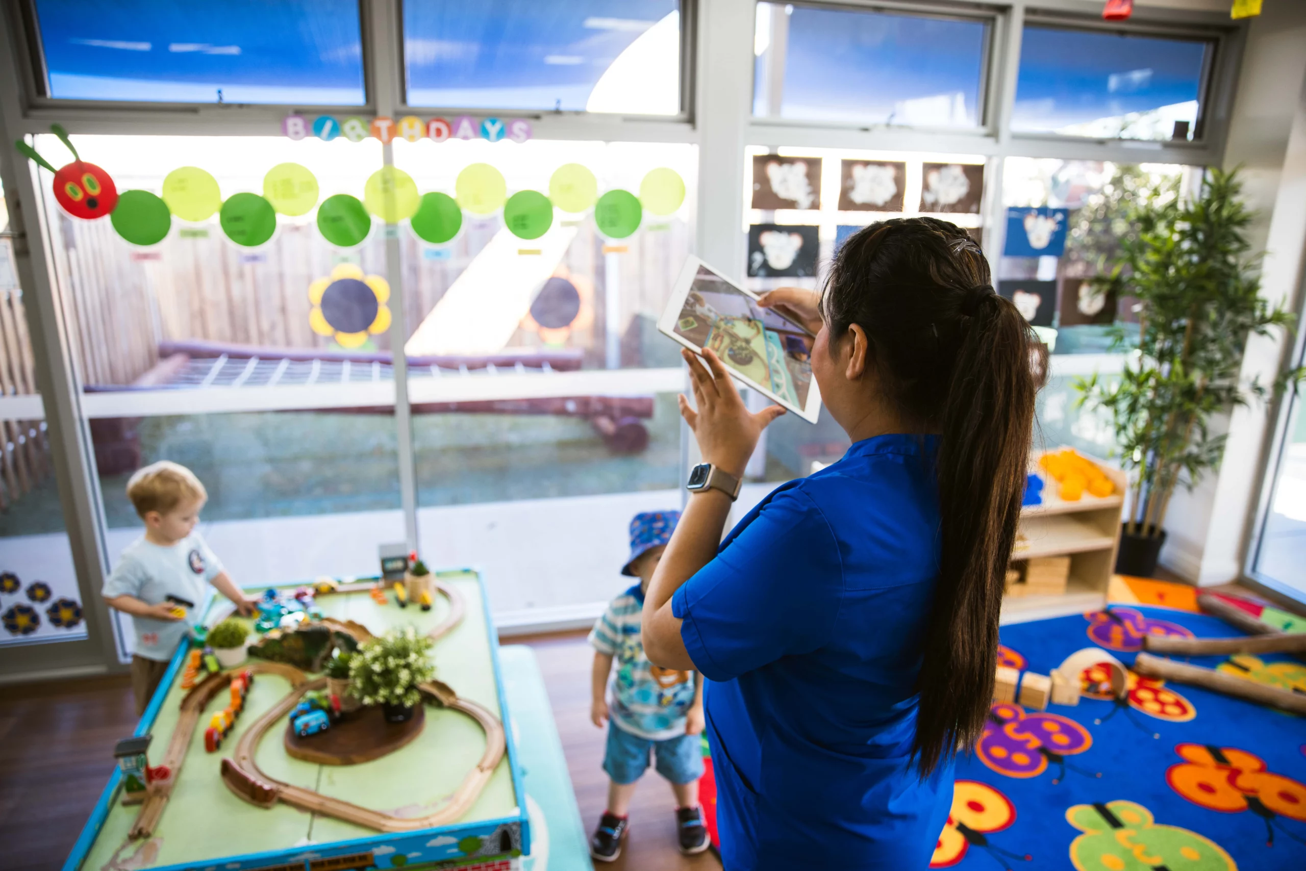 Educator capturing a moment of play-based learning at a Perth childcare centre, highlighting a vibrant and interactive environment for children.