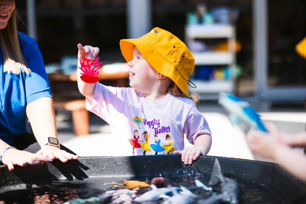 Child enjoying outdoor water play at a Perth childcare centre, with essentials packed in their daycare backpack for a fun and safe experience.