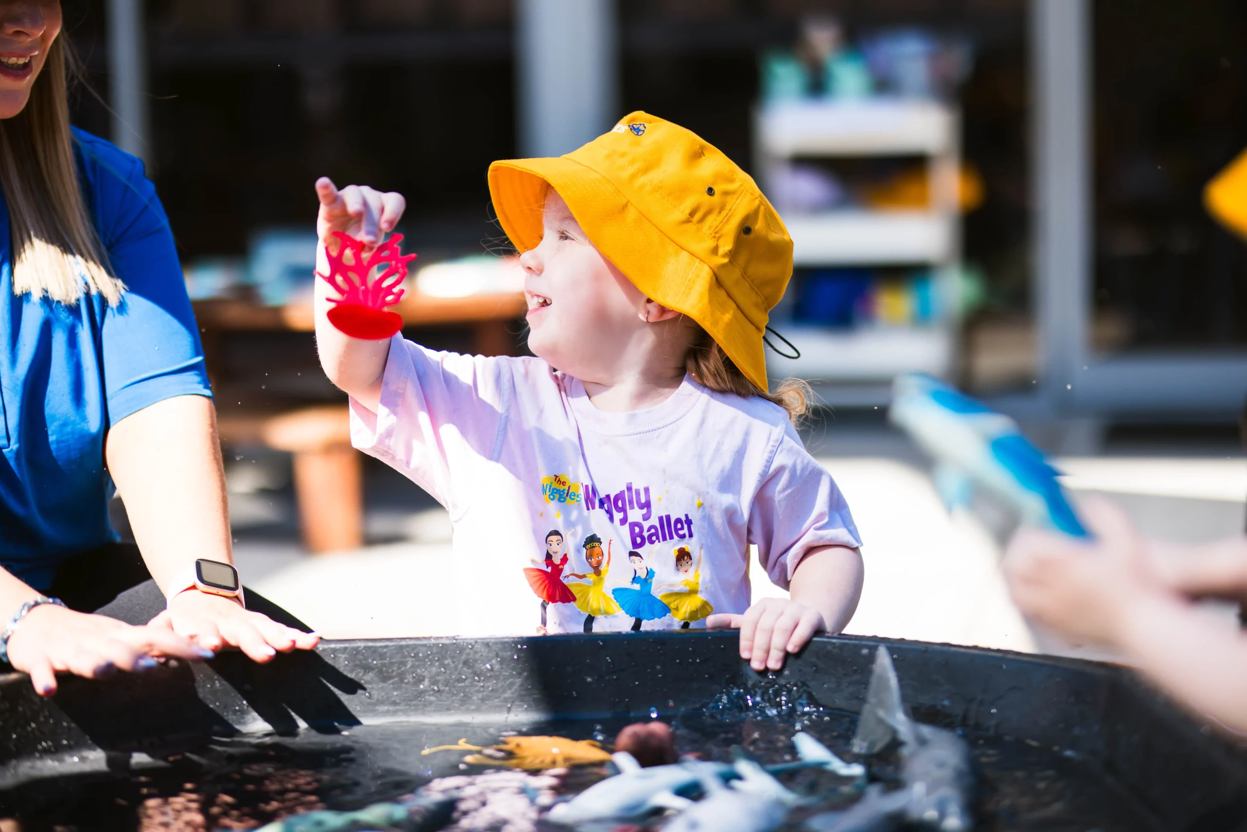 Child enjoying outdoor water play at a Perth childcare centre, fostering creativity and sensory exploration in a fun and safe environment.