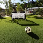 Outdoor play area at Buttercups Perth Childcare with lush artificial grass, a small soccer goal, and ball, encouraging active play and teamwork.