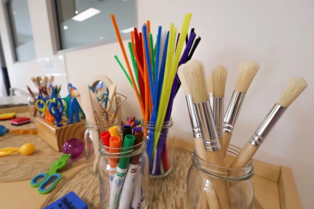 Creative art station at Buttercups Perth Childcare, featuring an array of colourful craft supplies, paintbrushes, and markers, designed to inspire creativity and self-expression in young learners.
