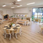 Bright and spacious classroom at Buttercups Perth Childcare, featuring natural wooden furnishings, interactive learning stations, and engaging activity areas designed to foster creativity.