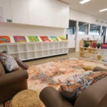 Indoor play area at Buttercups Perth Childcare showcasing a cosy reading nook, filled with a range of colourful books designed to engage children and support their learning and imagination.