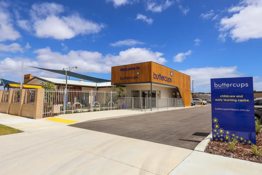 Buttercups Wellard Early Learning Centre as seen from the road, featuring a secure entryway and soft landscaping. A paved footpath and pram-friendly access points highlight the welcoming, purpose-built layout for families.
