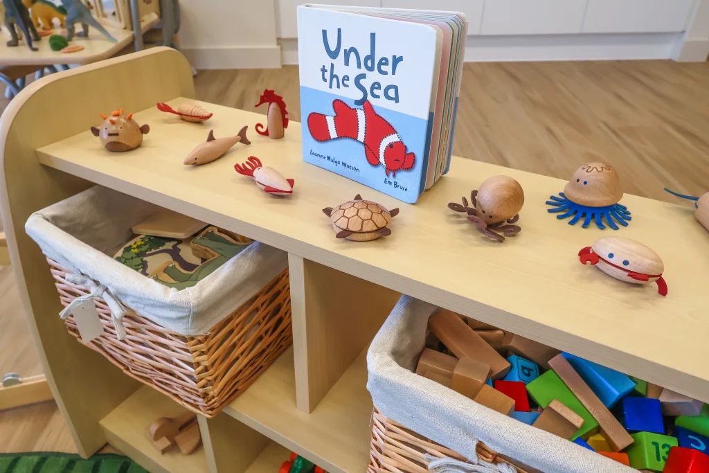 A learning shelf at Buttercups Perth Childcare displays wooden toys within easy reach. This low-level shelf is designed to encourage hands-on exploration and independent play for the littlest learners.