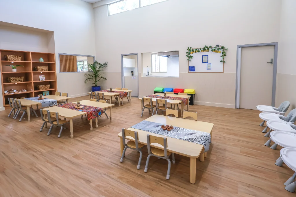 Wooden tables adorned with plants, creating a welcoming eating area at Buttercups Perth Childcare.