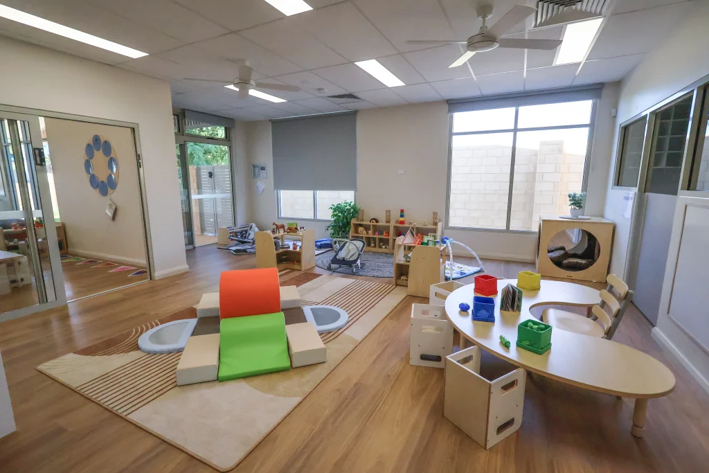 The indoor learning space at Buttercups Childcare and Early Learning Centre Lakelands features a spacious, open-plan layout with soft play equipment, low tables, and interactive learning zones. Large windows fill the room with natural light, creating a calm and engaging environment for early learning.