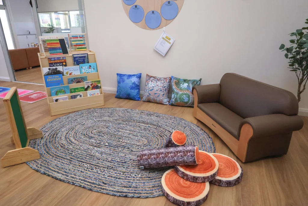 The cosy reading corner at Buttercups Childcare and Early Learning Centre Lakelands includes a soft rug, comfortable seating, and a display of children’s books within easy reach. This inviting space supports early literacy and quiet, independent exploration.