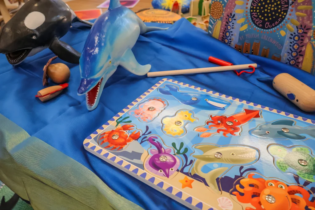 A close-up of an ocean-themed play activity at Buttercups Childcare and Early Learning Centre Lakelands features toy sea animals, a puzzle board, and sensory materials. This engaging setup supports imaginative play and early learning through exploration.